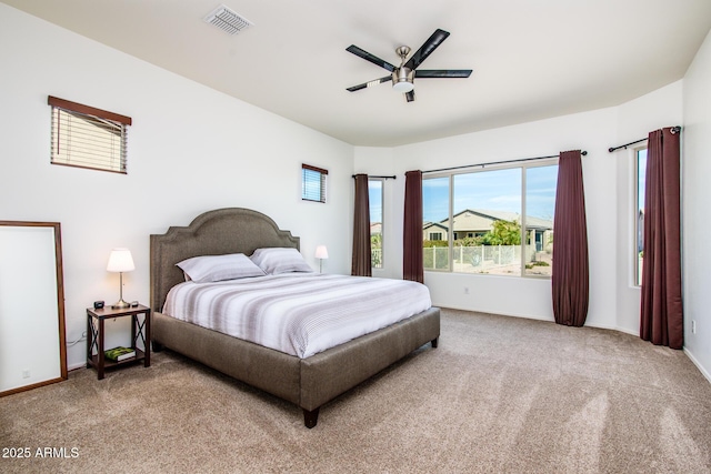 carpeted bedroom with a ceiling fan, visible vents, and baseboards