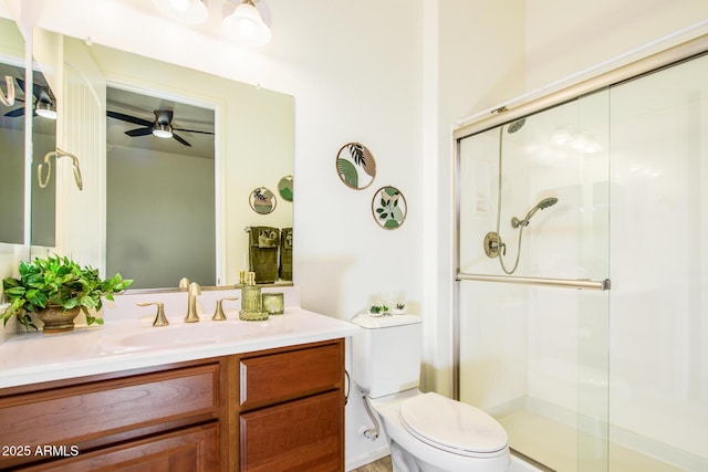 full bath featuring ceiling fan, a shower stall, toilet, and vanity