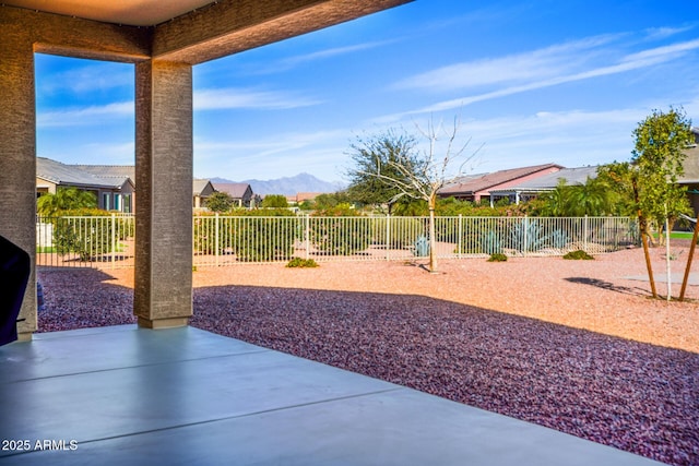 view of yard featuring a patio area, a fenced backyard, and a mountain view