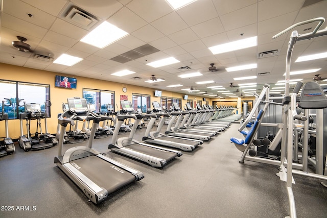 exercise room with a paneled ceiling and visible vents