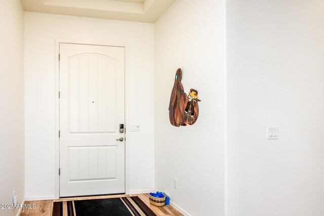 doorway with wood finished floors and baseboards