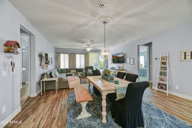 dining space with hardwood / wood-style flooring and an inviting chandelier