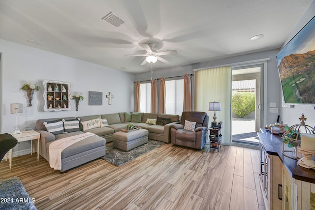 living room with light hardwood / wood-style floors, a wealth of natural light, and ceiling fan