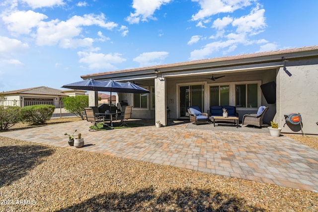 back of house with an outdoor living space, ceiling fan, and a patio area