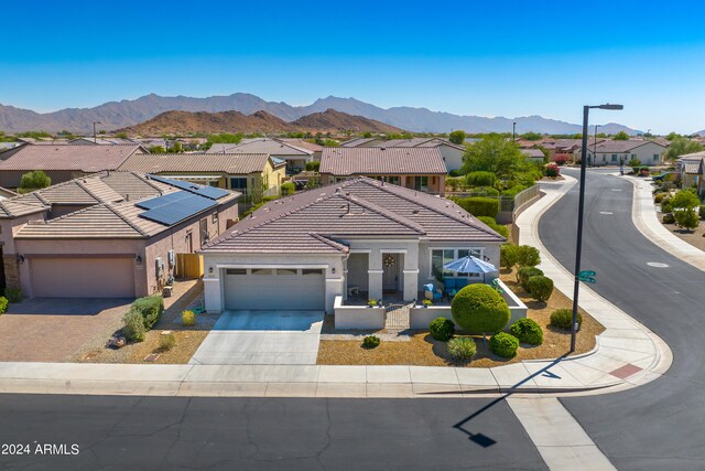 view of front of property featuring a mountain view, a garage, and solar panels