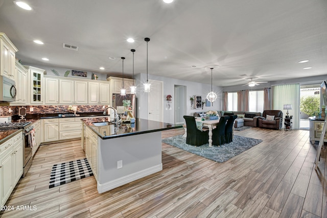 kitchen with pendant lighting, light wood-type flooring, and appliances with stainless steel finishes