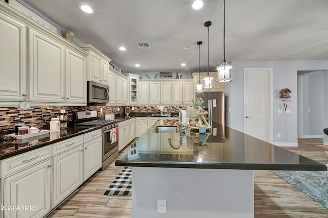 kitchen featuring appliances with stainless steel finishes, an island with sink, and sink