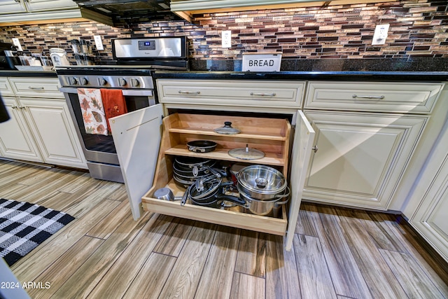 kitchen featuring backsplash, stainless steel stove, and light hardwood / wood-style floors