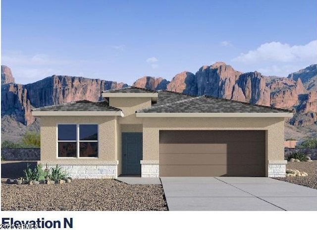 4940 S 106th Ln, Tolleson, AZ 85353 - prairie-style home featuring a garage, a mountain view, concrete driveway, and stone siding