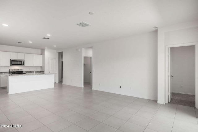 unfurnished living room with recessed lighting and visible vents