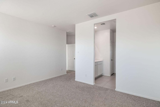 unfurnished bedroom with baseboards, visible vents, and light carpet