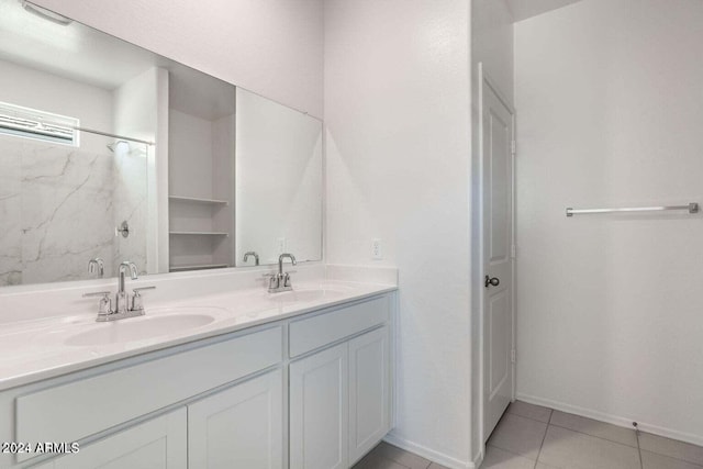 full bathroom with double vanity, a sink, baseboards, and tile patterned flooring