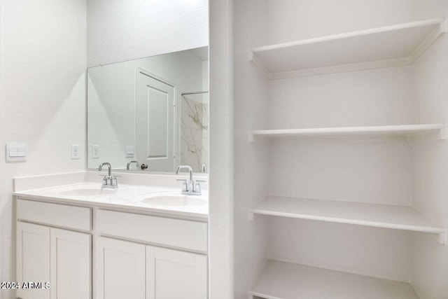 full bathroom featuring double vanity, a sink, and walk in shower