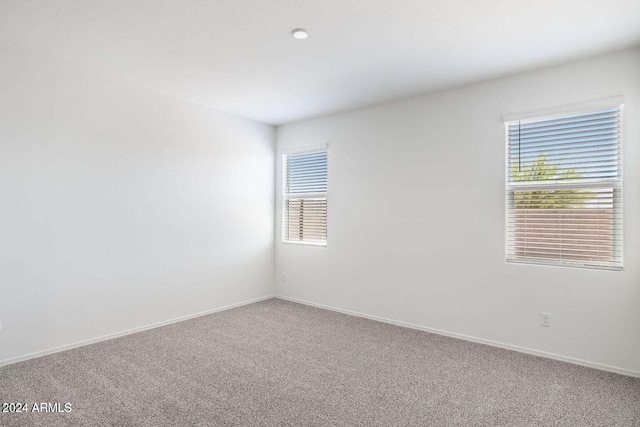carpeted spare room featuring baseboards