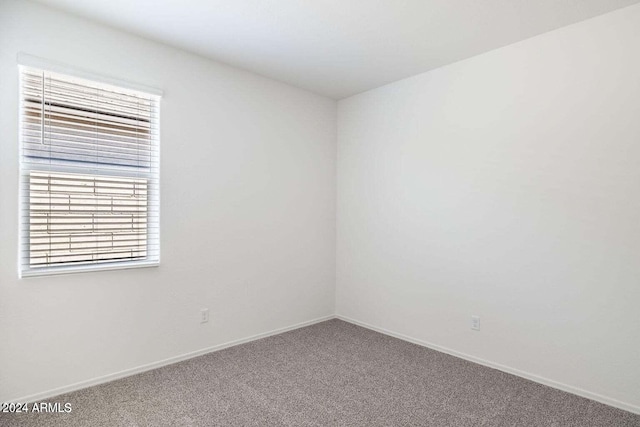 carpeted empty room with baseboards