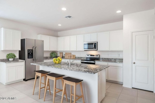 kitchen featuring light stone countertops, appliances with stainless steel finishes, light tile patterned floors, and visible vents