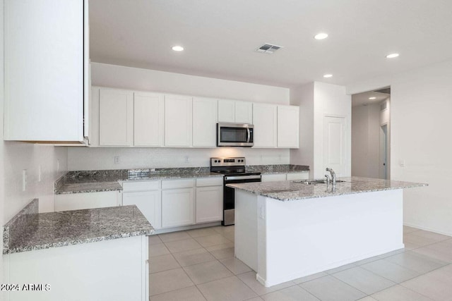 kitchen featuring a sink, light stone counters, stainless steel appliances, and visible vents