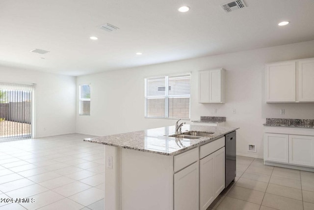 kitchen with visible vents, light stone countertops, dishwasher, a sink, and light tile patterned floors