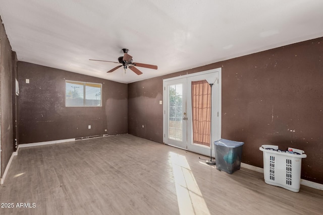 empty room featuring french doors, ceiling fan, and light hardwood / wood-style flooring