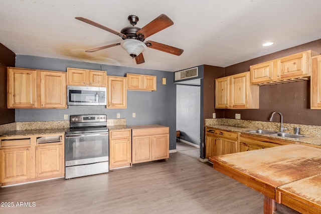 kitchen featuring sink, ceiling fan, stainless steel appliances, wood-type flooring, and light brown cabinetry