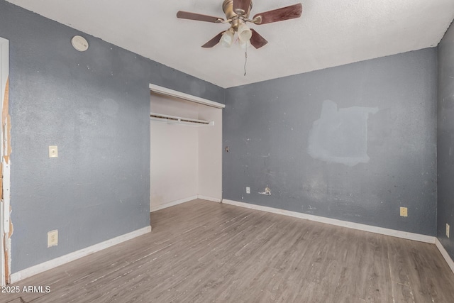 unfurnished bedroom with ceiling fan, wood-type flooring, and a closet