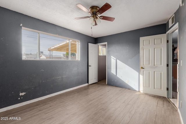 unfurnished bedroom with ceiling fan, wood-type flooring, and a textured ceiling