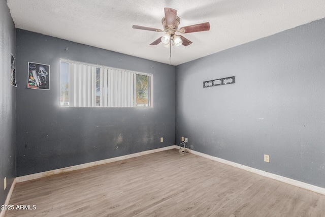 spare room featuring ceiling fan, light hardwood / wood-style floors, and a textured ceiling