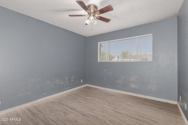 empty room with hardwood / wood-style floors and ceiling fan