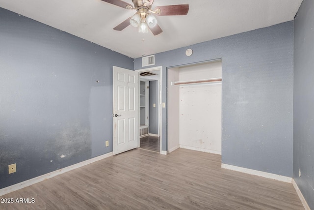 unfurnished bedroom with hardwood / wood-style floors, ceiling fan, and a closet