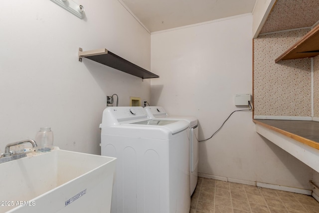 laundry room featuring ornamental molding, sink, and washing machine and clothes dryer