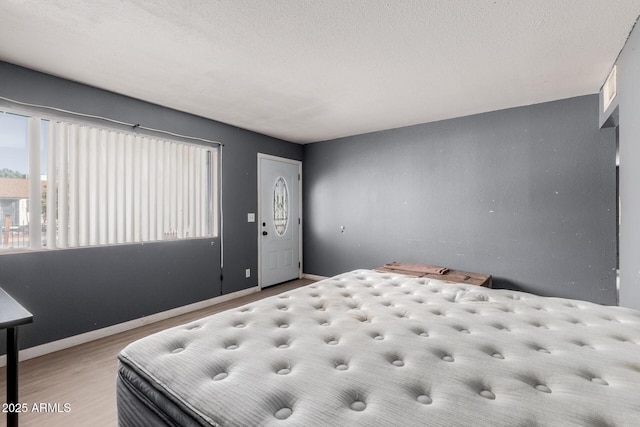 bedroom featuring light hardwood / wood-style flooring and a textured ceiling