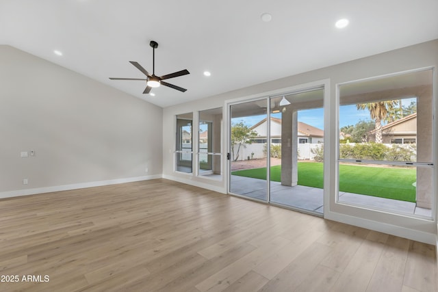 empty room with ceiling fan, light wood-type flooring, and vaulted ceiling