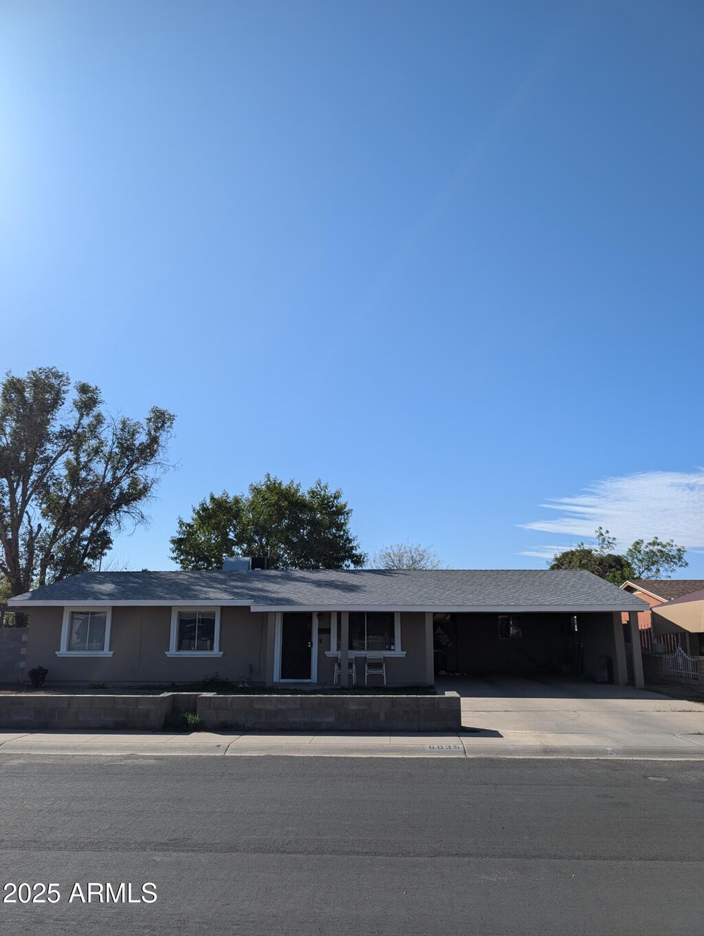 6035 W Columbus Ave, Phoenix, AZ 85033 - ranch-style home with an attached carport and concrete driveway