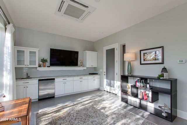 kitchen with backsplash, stainless steel dishwasher, and white cabinetry