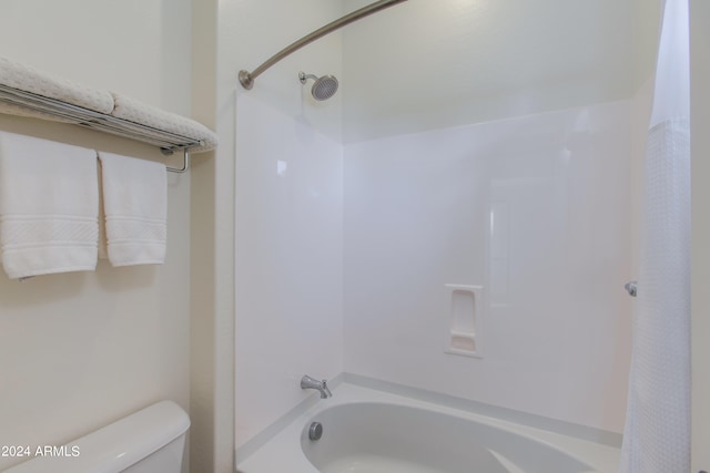 bathroom featuring shower / bath combo with shower curtain and toilet