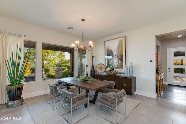 dining room featuring light tile patterned flooring and a notable chandelier