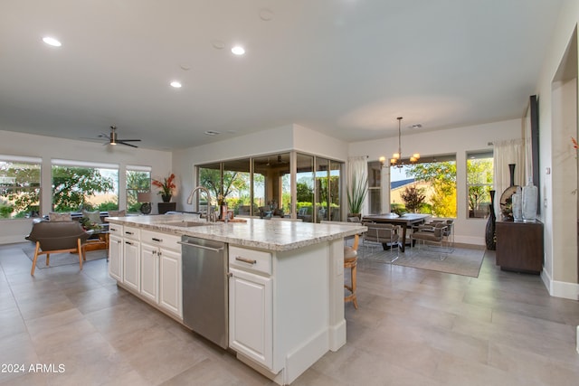 kitchen with an island with sink, white cabinets, a healthy amount of sunlight, and stainless steel dishwasher