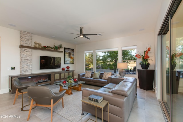 living room featuring ceiling fan and a fireplace