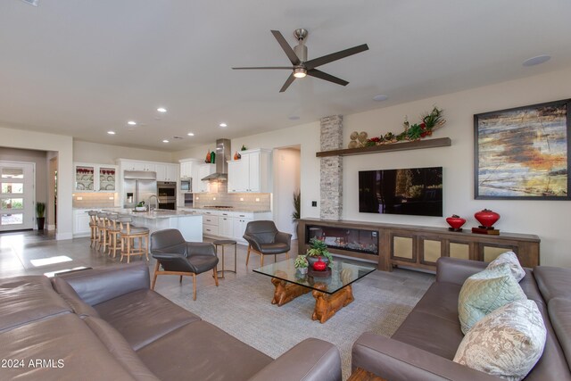 living room with ceiling fan and sink