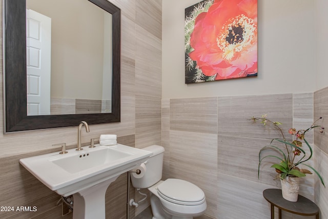 bathroom featuring tile walls and toilet