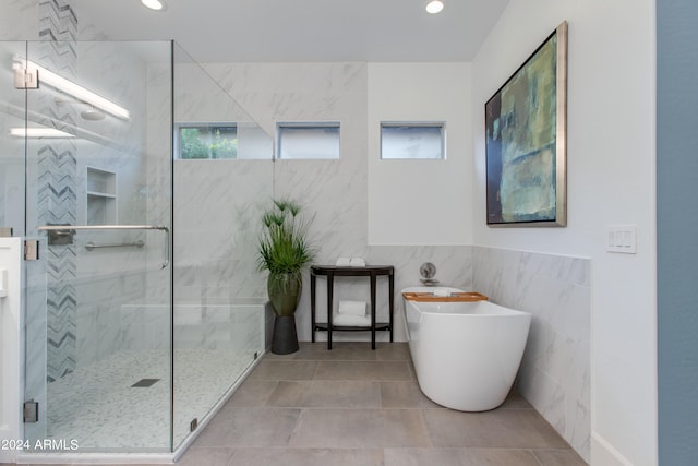 bathroom featuring tile walls, tile patterned flooring, and plus walk in shower