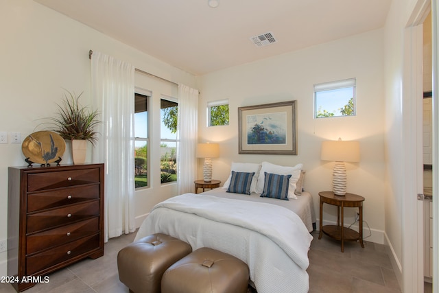 bedroom with multiple windows and light tile patterned floors