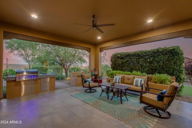 patio terrace at dusk featuring an outdoor living space, exterior kitchen, ceiling fan, and a grill