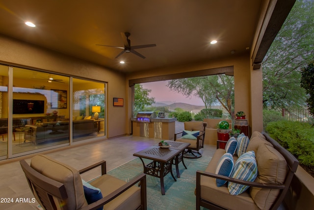 patio terrace at dusk with grilling area, an outdoor living space, and ceiling fan