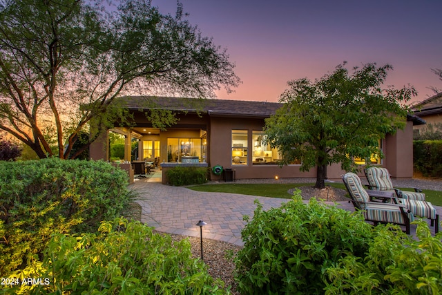 back house at dusk with an outdoor hangout area and a patio area