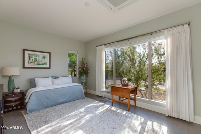 bedroom featuring dark tile patterned flooring and multiple windows