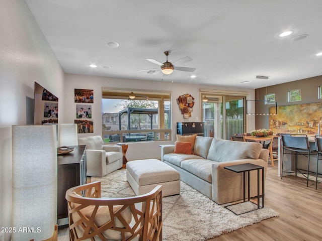 living room with light hardwood / wood-style flooring and ceiling fan