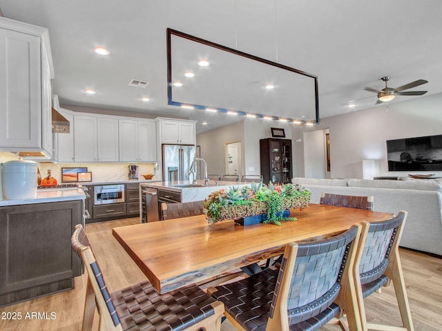 dining area with ceiling fan and light wood-type flooring