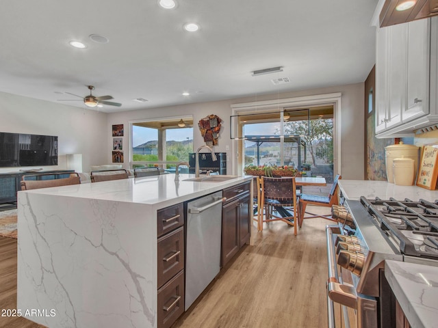 kitchen with stainless steel appliances, sink, light hardwood / wood-style flooring, and a wealth of natural light