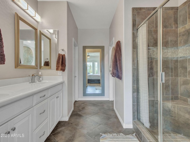 bathroom with a shower with door, vanity, and tile patterned flooring